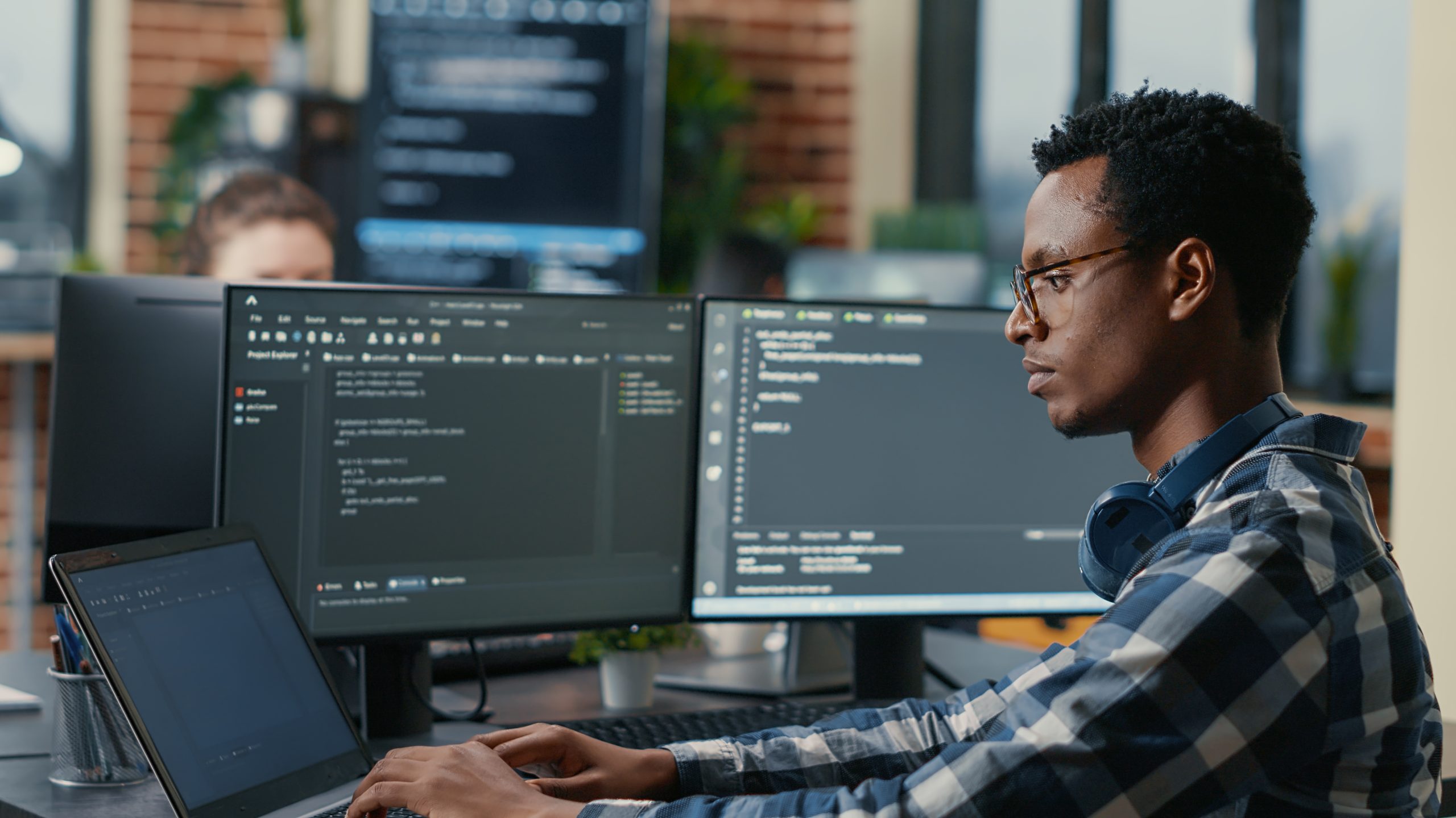 sofware-developer-thinking-while-touching-beard-while-typing-laptop-sitting-desk-with-multiple-screens-parsing-code-focused-database-admin-working-with-team-coding-background introduction to cybersecurity class
